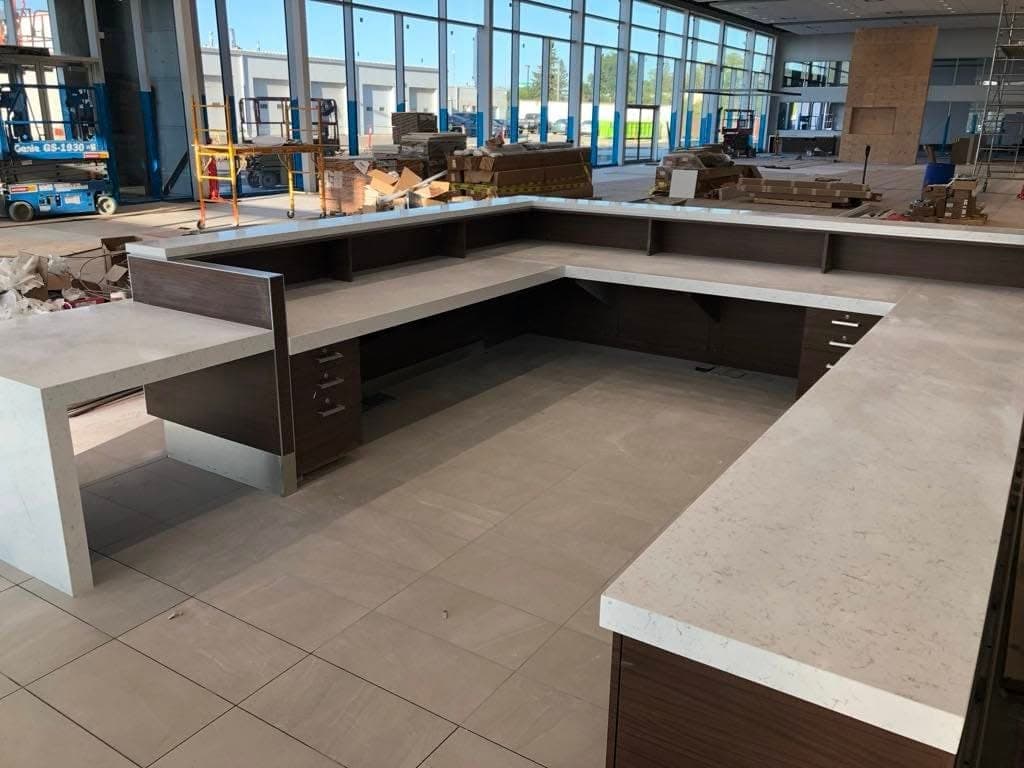 Black Pearl Granite countertop — Customer lounge + reception at Toyota on Regent, Winnipeg